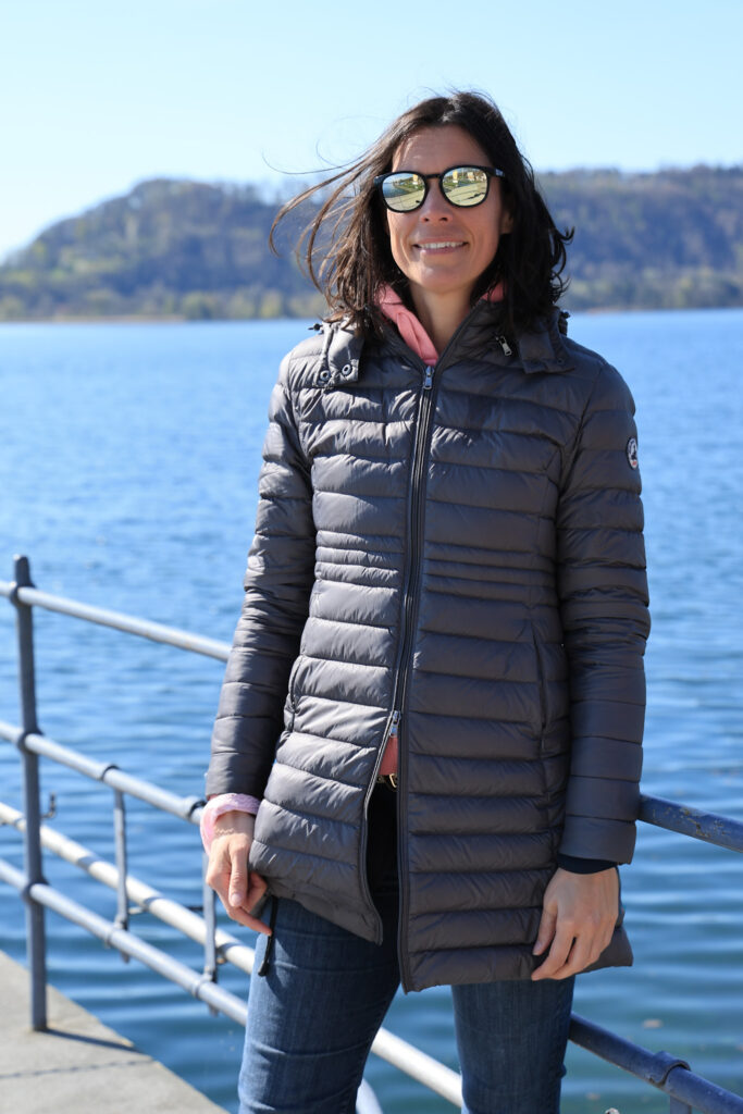 Amandine Devergies souriante sur le ponton du port de La Neuveville, avec le lac de Bienne en arrière-plan.