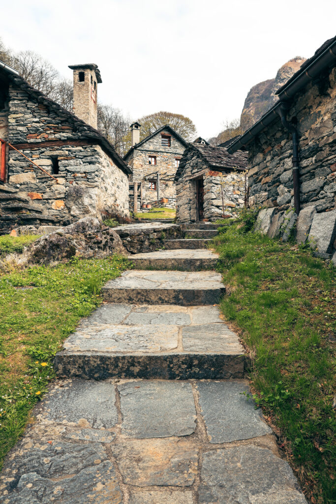 Escaliers en pierre d'un village tessinois menant vers une maison, symbole d'un chemin balisé étape par étape