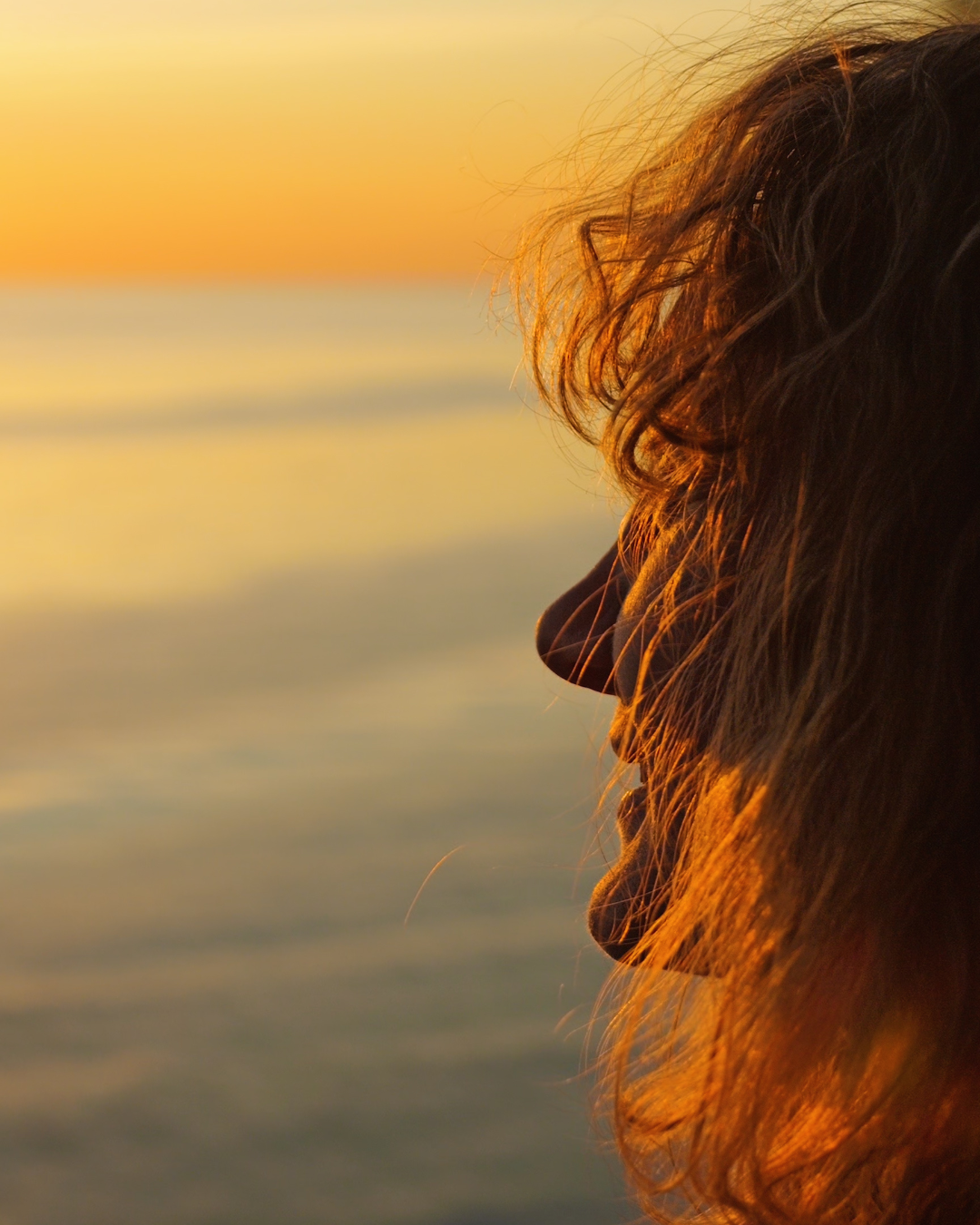 Silhouette d'une personne regardant un coucher de soleil, seule face à l'horizon