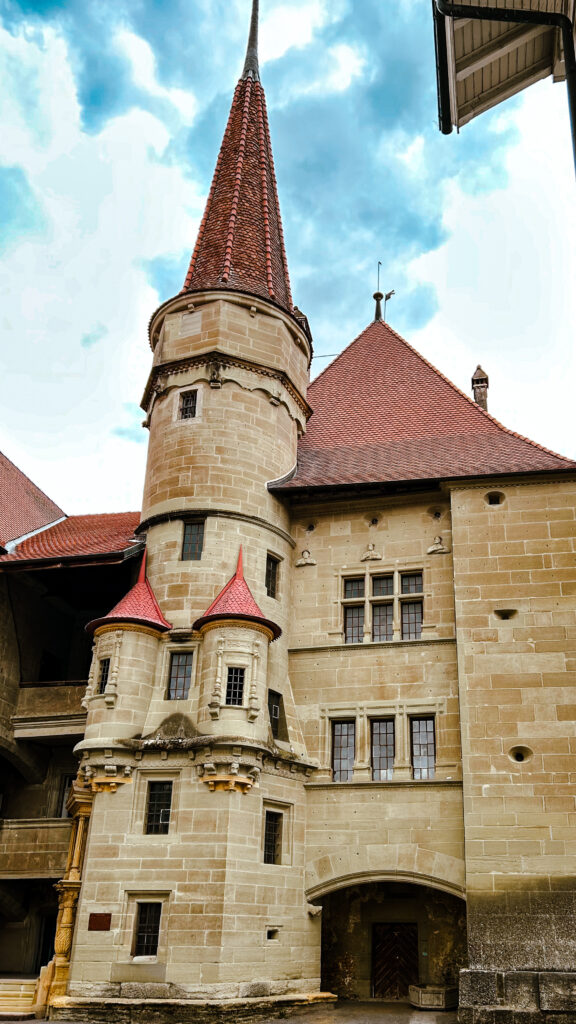 ourelle en pierre et toit conique rouge d'un château romand